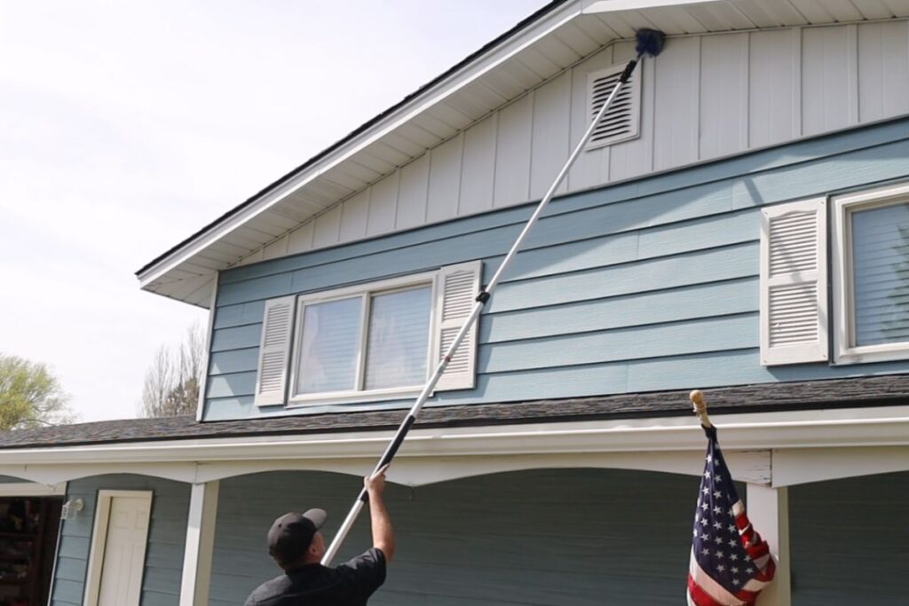 Tech Sweeping for cobwebs and wasps in eaves
